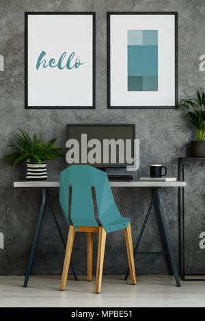 Turquoise chair, desk, mock-up posters in gray office interior Stock Photo