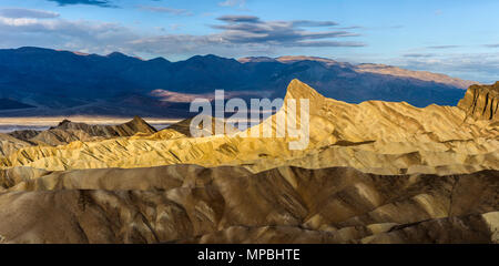 Sunrise at Zabriskie Point - A panoramic sunrise view of Manly Beacon and surrounding rock formations. Zabriskie Point, Death Valley National Park, US Stock Photo