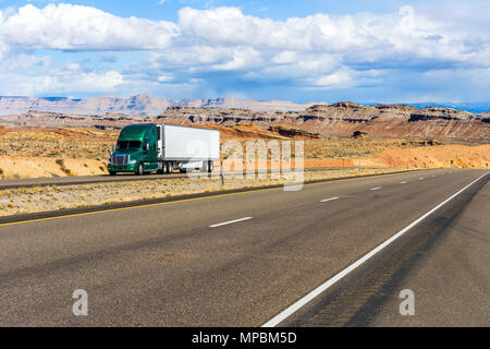 Desert Highway - A semi-trailer truck driving on Interstate Highway I-70 in colorful desert land, Utah, USA. Stock Photo