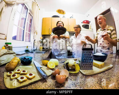 funny scene indoor at home in the kitchen woth a man that fly an omelette and fathers looking for it. everybody have fun in a crazy situation. family  Stock Photo