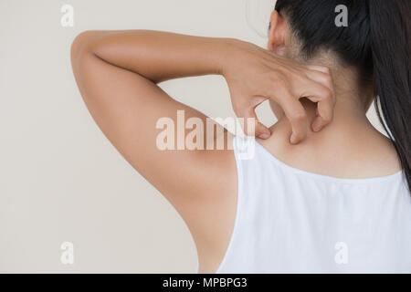 Close up woman hand scratch the itch by hand at neck and back. Healthcare and medical concept. Stock Photo