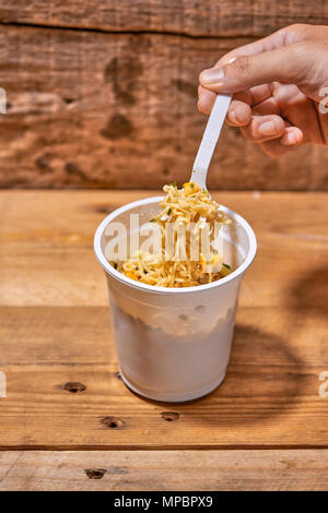 instant noodle, asian fast food, noodle cup on wooden background. Stock Photo