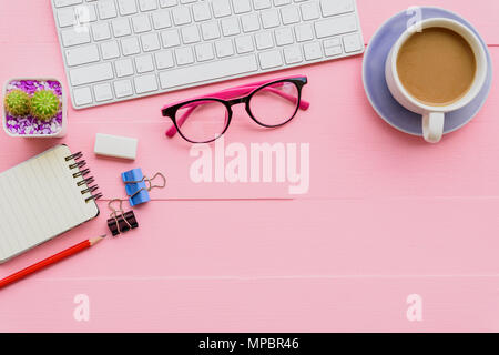 Top view office table with workspace and office accessories including calculator, mouse, keyboard, glasses, clips, flower, pen, pencil, note book, lap Stock Photo