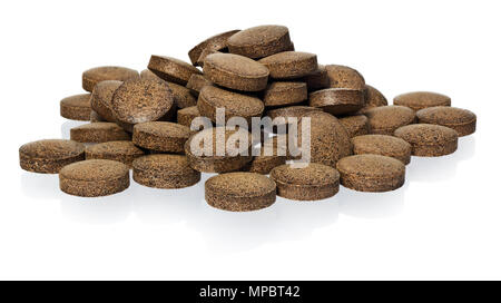 Herbal pills from Ashwagandha (Withania somnifera), Indian ginseng. Ayurvedic medicine herb. Pills in brown color isolated on a white background with  Stock Photo