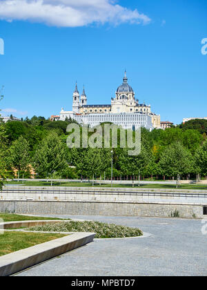 Green spaces of Madrid Rio at spring day with the Almudena Cathedral in background. Madrid, Spain. Stock Photo