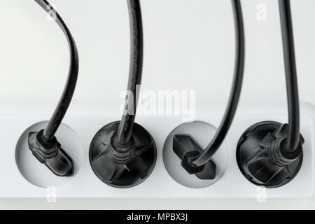 a lot of plugs connected in an extension cord on a white background. Distribution of energy. power supply of electrical appliances from electrical net Stock Photo