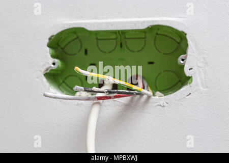 Unfinished electrical mains outlet socket with electrical wires and TV cable - connector installed in plasterboard drywall for gypsum walls in apartme Stock Photo