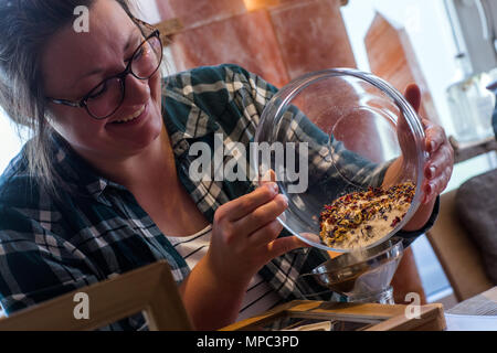 27 April 2018, Germany, Trinwillershagen: A visitor mixes her own salt mix from various salts, herbs, and spices. With its three-story salt tower and the six-metre high graduation tower, the Salzreich offers salt therapies, singing bowl massages, and healing applications for the upper respiratory tract, and provides information on everything salt-related. A total of 35 tons of salt blocks from Pakistan were processed over the course of the past few years. Photo: Jens Büttner/dpa-Zentralbild/ZB Stock Photo