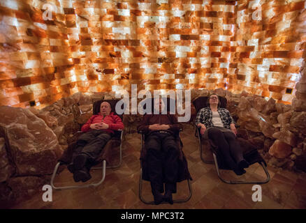 27 April 2018, Germany, Trinwillershagen: Visitors relax in the salty air of a room furnished with salt blocks from Pakistan in the Salzreich, which includes a three-story salt tower and the six-metre high graduation tower. The Salzreich offers salt therapies, singing bowl massages, and healing applications for the upper respiratory tract, and provides information on everything salt-related. A total of 35 tons of salt blocks from Pakistan were processed over the course of the past few years. Photo: Jens Büttner/dpa-Zentralbild/ZB Stock Photo