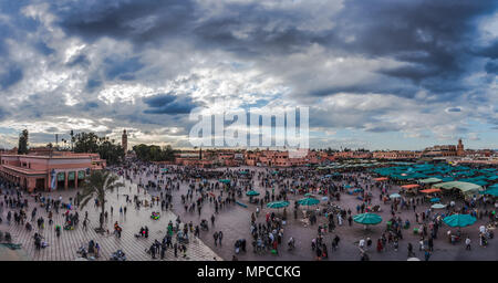 aerial view of people walking on Jemaa EL Fnaa main city square. Crowd at warm sunset color tones at market place in Marrakesh's medina quarter. Stock Photo
