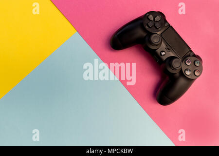 LONDON - MAY 18, 2018: Video games PlayStation gaming controller isolated on yellow pink background Stock Photo