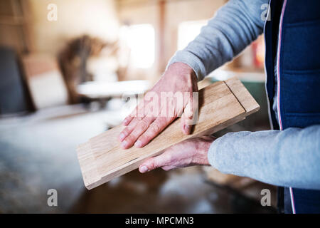 An unrecognizable man worker in the carpentry workshop, working with wood. Stock Photo