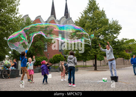 Europe, Germany, Cologne, man makes huge soap bubbles at the Rhine garden in the old part of the town.  Europa, Deutschland, Koeln, Mann macht grosse  Stock Photo