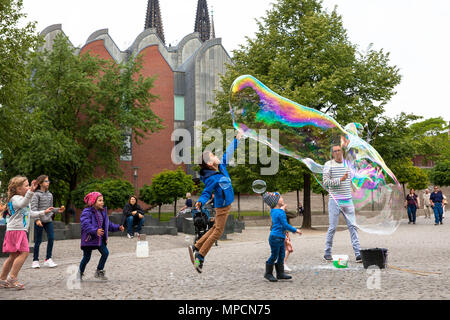 Europe, Germany, Cologne, man makes huge soap bubbles at the Rhine garden in the old part of the town.  Europa, Deutschland, Koeln, Mann macht grosse  Stock Photo