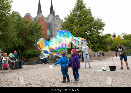 Europe, Germany, Cologne, man makes huge soap bubbles at the Rhine garden in the old part of the town.  Europa, Deutschland, Koeln, Mann macht grosse  Stock Photo