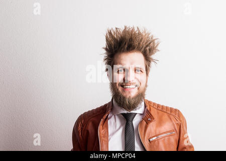 Portrait of a young hipster man with messy hairstyle in a studio. Copy space. Stock Photo