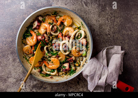 Fried seafood octopus shrimps squids in pan, top view. Stock Photo