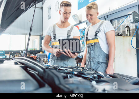 Experienced auto mechanic using a laptop for scanning engine error codes Stock Photo
