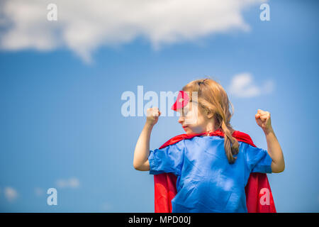 Funny little girl playing power super hero. Stock Photo