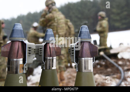 U.S. Paratroopers assigned to the 4th Battalion, 319th Airborne Field Artillery Regiment, fire precision guided munitions from M777 Howitzers while conducting Artillery Gunnery Table XVIII at the 7th Army Training Command’s Grafenwoehr Training Area, Germany, Feb. 3, 2017. The Exercise trains and evaluates the Battalion's ability to mass fires in direct support of the 173rd Airborne Brigade. Evaluators from the 82nd DIVARTY assisted the battalion by objectively reviewing its timeliness and accuracy of massed fires while firing in support of a heavy weapons company defensive live fire exercise. Stock Photo