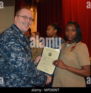 170208-N-SP496-013 SILVERDALE, Wash. (Feb. 8, 2017) – Capt. Alan Schrader, Naval Base Kitsap (NBK) commanding officer, presents Aviation Boatswain's Mate, (Handling) Airman Sashagaye McKenzie with the Good Conduct Medal during an all-hands call held at the NBK-Bangor Theater. More than 30 awards and decorations were bestowed to NBK personnel during the event. (U.S. Navy photo by Petty Officer 3rd Class Jane Wood/Released) Stock Photo