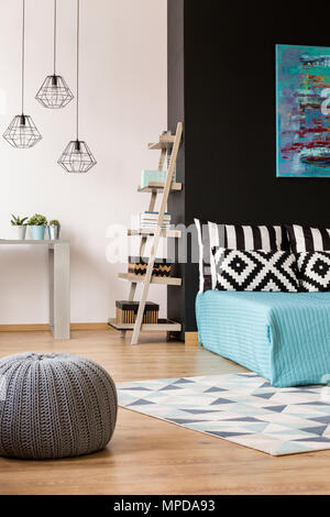 Black and white home interior with bed, desk, regale and wool pouf Stock Photo