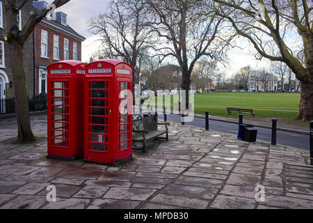 Two red telephone boxes on the corner of Richmond Green Stock Photo