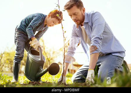 Nice serious man sitting on the ground Stock Photo