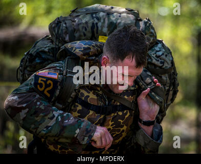 U.S. Army Capt. Timothy Cox, 3rd Chemical Brigade Ranger, puts on his ruck during the Best Ranger Competition 2017 in Fort Benning, Ga., April 9, 2017. The 34th annual David E. Grange Jr. Best Ranger Competition 2017 is a three-day event consisting of challenges to test competitor's physical, mental, and technical capabilities. Stock Photo