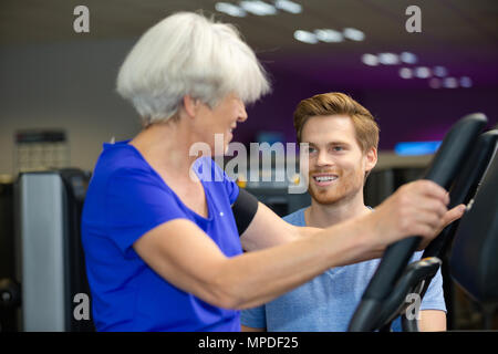 senior woman doing exercises with coach Stock Photo