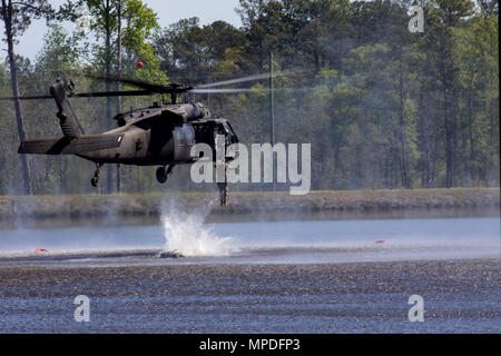 U.S. Army Rangers perform a helocast water insertion technique from a UH-60 Black Hawk helicopter during the Combat Water Survival Assessment portion of the 34th annual David E. Grange Jr. Best Ranger Competition at Ft. Benning, Ga., Apr. 9, 2017. The Best Ranger competition is a three-day event consisting of challenges to test competitor's physical, mental, and technical capabilities, and places the military's best two-man Ranger teams against each other to compete for the title of Best Ranger. Stock Photo