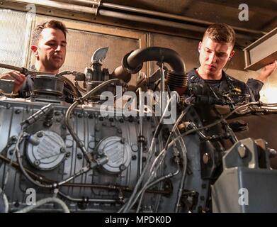 170303-N-RM689-239  SOUTH CHINA SEA (March 3, 2017) Gas Turbine System Technician 2nd Class Andrew Mesenbrink (left), from Killen, Alabama, teaches Lt. j.g. Michael Murphy, from Indianapolis, Indiana, about gas turbine generators during a tour of an engine room aboard Arleigh Burke-class guided-missile destroyer USS Wayne E. Meyer (DDG 108). Wayne E. Meyer is on a regularly scheduled Western Pacific deployment with the Carl Vinson Carrier Strike Group as part of the U.S. Pacific Fleet-led initiative to extend the command and control functions of U.S. 3rd Fleet into the Indo-Asia-Pacific region Stock Photo