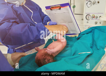 Registering newborn baby in clinic. Doctor take footprint of newborn Stock Photo