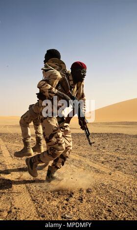 A Chadian Army Soldier assists a simulated casualty during a simulated assault in Faya-Largeau, Chad Mar. 3, 2017 as part of Flintlock 17. Flintlock is an annual special operations exercise involving more than 20 nation forces that strengthens security institutions, promotes multinational sharing of information, and develops interoperability among partner nation in North and West Africa. (Army photo by Sgt. Derek Hamilton) Stock Photo