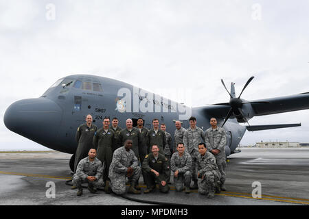 Members of the C-130J delivery team pose for a photo in front of a C-130J Super Hercules at Kadena Air Base, Japan, March 6, 2017. This is the first C-130J to be assigned to Pacific Air Forces.  Yokota serves as the primary Western Pacific airlift hub for U.S. Air Force peacetime and contingency operations. Missions include tactical air land, airdrop, aeromedical evacuation, special operations and distinguished visitor airlift. (U.S. Air Force photo by Staff Sgt. Michael Smith) Stock Photo