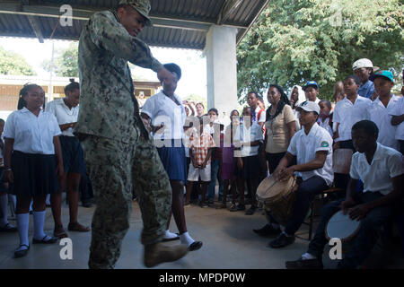 170227-N-WZ792-227 TRUJILLO, Honduras (Feb. 27, 2017) - Equipment Operator 2nd Class Elijah Godbold, a native of Augusta, Ga., Assigned to Construction Battalion Maintenance Unit (CBMU) 202, dances with host nation children during a cultural demonstration during Continuing Promise 2017 (CP-17) in Trujillo, Honduras.  CP-17 is a U.S. Southern Command-sponsored and U.S. Naval Forces Southern Command/U.S. 4th Fleet-conducted deployment to conduct civil-military operations including humanitarian assistance, training engagements, medical, dental, and veterinary support in an effort to show U.S. sup Stock Photo