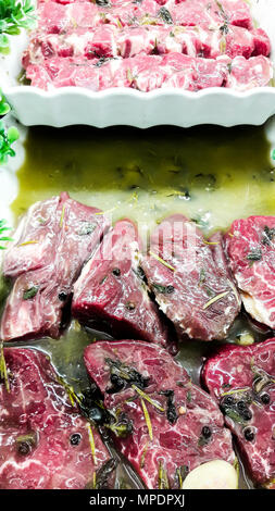Juicy raw beef tendorlin with greens and olive oil at butcher. organic food Stock Photo