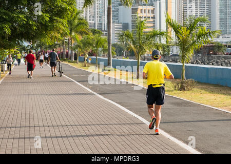 people running in public park with city skyline in background, Panama city Stock Photo