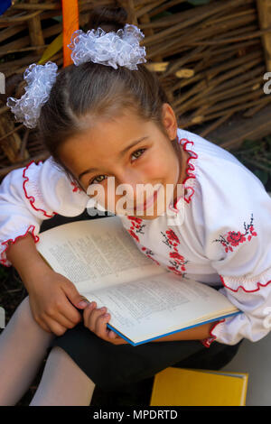 Beautiful little girl 7 years in embroidery books. top view Stock Photo