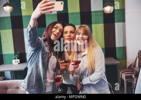 Picture presenting happy group of friends with red wine taking selfie Stock Photo