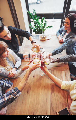 View from the top. Hands of people with glasses of whiskey or wine, celebrating and toasting in honor of the wedding or other celebration Stock Photo