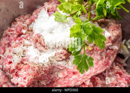 Mixe of ground meat minced beef and pork with parsley salt with ground pepper and onions for cooking barbecue steaks kebabs sausages fried on fire Foo Stock Photo