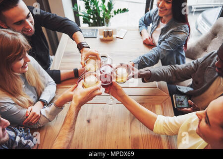 View from the top. Hands of people with glasses of whiskey or wine, celebrating and toasting in honor of the wedding or other celebration Stock Photo