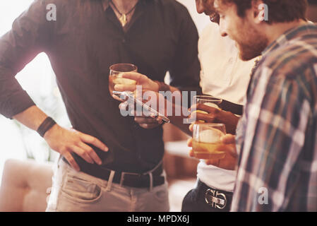 Whiskey. Group of friends guys with glasses of whiskey. Concept party, bachelor party barbershop. Stock Photo