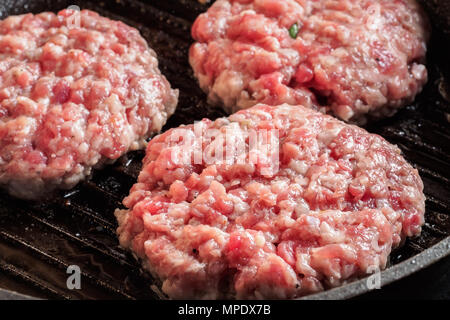 Cutlets steaks grilled frying pan Mixe of ground meat minced beef and pork for cooking barbecue steaks kebabs fried Food Stock Photo