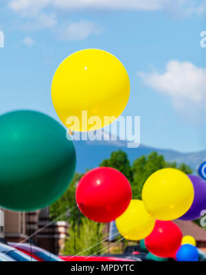 Pan; blur; motion view of colorful balloons; windy day; automobile dealership; Salida; Colorado; USA Stock Photo