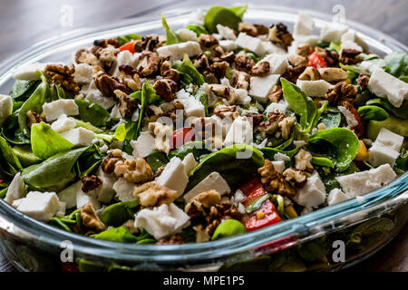 Salad with walnut, cheese and cherry tomatoes in glass bowl. Organic food concept. Stock Photo