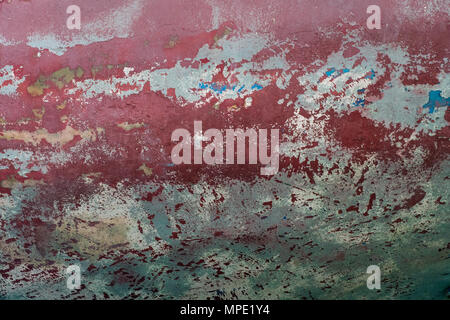 Abstract grunge background burgundy wall with spots of blue and green, soft glare on the surface. Stock Photo