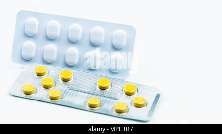 Ergotamine drug interactions concept. Yellow tablet pills and white blister pack. Migraine headache treatment with pills. Pharmaceutical industry. Bac Stock Photo