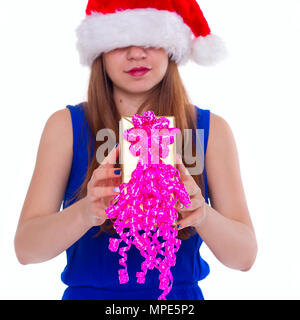 Young happy girl in Christmas hat. Standing indoors and holding huge christmas gift. isolate Stock Photo
